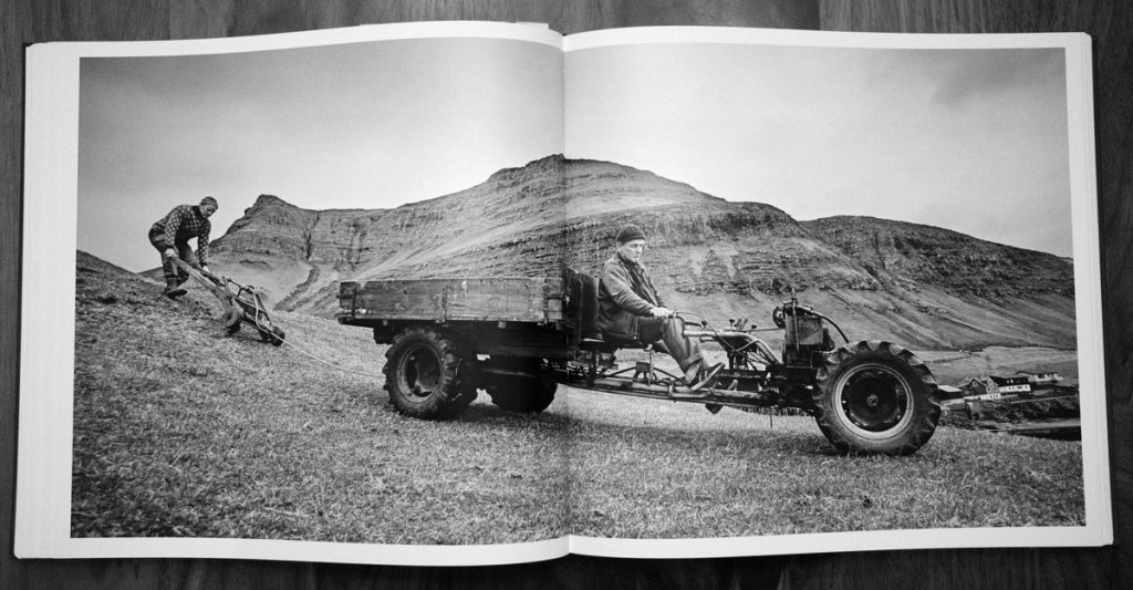 Photo of two men and an old tractor in the Faroe Islands, from Faces of the North